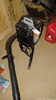 Full view of the Echo backpack leaf blower laid on the floor showing flexible hose and blower tube.