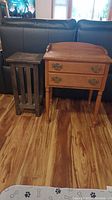 Both the mission style plant stand and the wooden two drawer side table shown side by side, displaying their overall appearance and size.