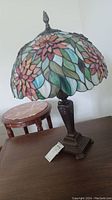Full view of lamp showing stained glass shade and metal base