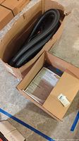 Boxes containing black vacuum hose and car vacuum parts.