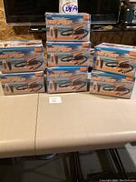 Eight new in box Stermay SUP Air Pumps stacked on table.