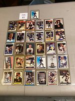 Lot of 27 Brett Hull hockey cards arranged on a table, all in plastic sleeves, showing different designs and years, mostly featuring the St. Louis Blues uniform.