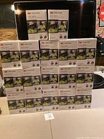 Stack of 33 white boxed 3M Peltor hearing protection earmuffs designed to attach to hard hats.