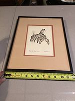 Framed Indigenous art featuring an orca/whale design, ruler for scale showing about 12 inches wide.