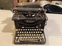 Front view of vintage typewriter showing keyboard and metal frame.