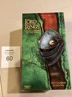 Front of box showing Lord of the Rings Fellowship of the Ring Orc Crowfaced 1/4 Scale Helmet collectible packaging.