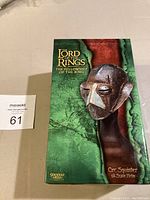 Front of the box showing Orc Squinter Helm image, item title, and series name.