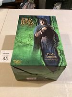 Box front showing Frodo Baggins figure branding and Lord of the Rings Fellowship of the Ring title with green map background.