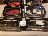 Six boxed model cars including Maisto Special Edition and Bburago brands in various colors and models