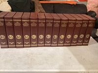 Photo of 13 National Geographic magazine binders with maroon covers and gold embossed text including years from 1995 to 2000s