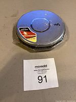 Top view of silver Sony Walkman portable CD player showing Digital Mega Bass and CD-R/RW labels, with usage marks and scratches visible.