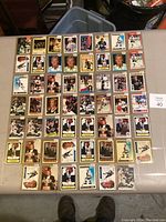Top-down image showing 52 Wayne Gretzky hockey cards laid out on a table, all sleeved in plastic, showing various card designs and years.