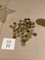 Overview photo showing assorted world coins spread out on a flat surface, highlighting variation in size and metal color.