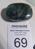 Top view of large polished emerald gemstone showing rectangular shape and natural inclusions.