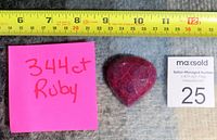 Photo showing the ruby gemstone with a measuring tape indicating around 4 cm width and a sticky note with '344 ct Ruby' written on it.
