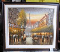 Front view of the framed painting showing the street scene with the Eiffel Tower, pedestrians and horse carriages in warm sunset light.