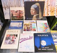 Overview of the art books arranged on a surface, includes Vermeer, pastel and acrylic, abstract art, and more.