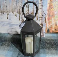 Black metal lantern with candle inside, front view with door closed