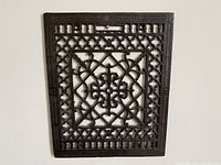 Front view of the cast iron floor grate showing full ornate design and frame