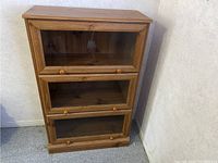 Photo showing front view of wooden barrister bookcase with three glass panel doors closed.