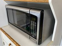 Right side angle view of Danby microwave showing brushed stainless steel and black finish with digital keypad.