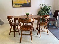 Vintage solid wood oval dining table with four matching spindle back chairs, in very nice condition.