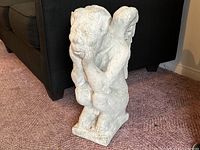Side angled view of the concrete gargoyle statue showing wing and posture details