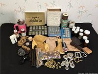 Wide shot showing full collection of leather crafting tools and supplies including alphabet stamp sets, leather pieces, cords, beads, and hardware.