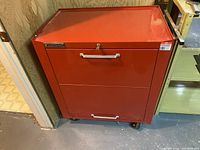 Front view of closed red tool chest cabinet on casters