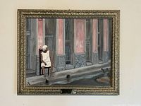 Front view of the framed oil painting showing a seated elderly woman outside old city buildings with textured and muted color walls.