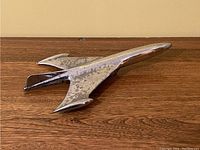 Top angled view of the chrome jet airplane hood ornament with some patina on the surface.