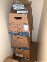 Stack of three sealed cardboard boxes for TOTO C703 #01 Cotton round toilet bowls.