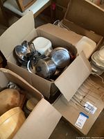 Box with additional cookware, pots, and CorningWare dishes, some plastic containers