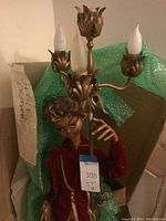 Upper section showing elf head and three-light metal candelabra top