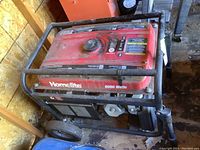 Top angled view of the red Homelite HG 6000 generator showing metal frame and control panel area.