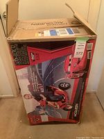 Box of Lightning McQueen 6V electric child's scooter showing full packaging with graphics and labels.