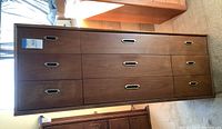 Full front view showing six-drawer layout and brass-tone recessed handles