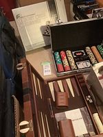 Photo showing the poker chip set in open aluminum case alongside the boxed electronic sensory chess challenger and the backgammon set.