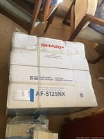 Boxed Sharp window-type room air conditioner model AF-S125NX with white packaging showing the model number and brand.