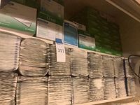 Shelves stocked with stacked sealed Curad non-adherent pad boxes and SureSite Window dressing boxes