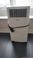 Front view of Haier portable AC unit with power cord wrapped around body