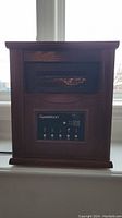 Front view of Garrison portable heater showing wood exterior, vent panel and electronic control panel.