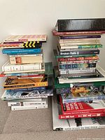 Stack of various non-fiction books showing titles about art, travel, nature, cooking, and history.
