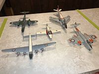 Photo showing five vacuum formed plastic model airplanes on table including various military aircraft models