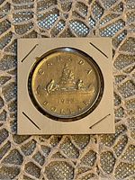 Reverse side of the 1952 Canadian silver dollar coin displaying the canoe design and denomination.