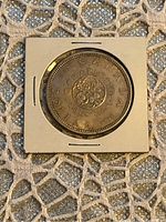 Obverse side of the 1964 Canadian Silver Dollar showing floral design, date, and denomination.