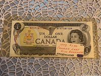 Front side of the 1973 $1 Canadian Bank Note showing the serial number BFH7181109 and portrait detail.
