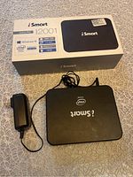 iSmart mini PC device with power adapter and original box displayed on a table.