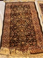 Dark brown Persian praying mat rug fully spread out on a flat surface with clear view of pattern and condition