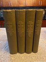 Front view showing the four 1913 volumes of the Royal Commission on Industrial Training and Technical Education with gilt titles on olive green cloth hardcovers.